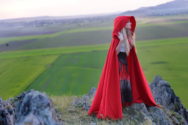 Bella donna bionda con mantello rosso in piedi a piedi nudi nel w — Foto Stock
