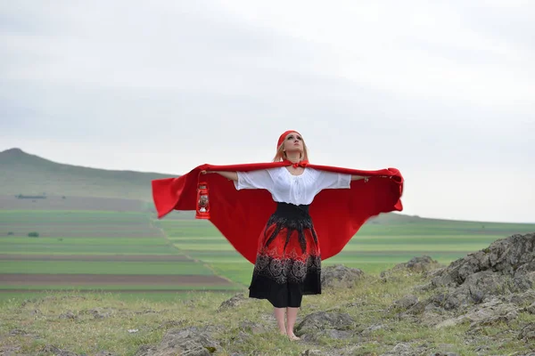 Kırmızı pelerini w içinde yalınayak duran güzel sarışın kadınla — Stok fotoğraf