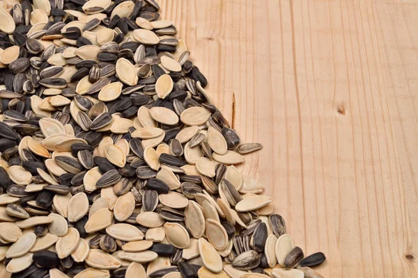 Macro image of different sunflower and pumpkin seeds on wooden b