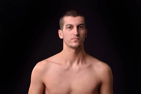 Picture of a young man shirtless posing in a studio, looking at — Stock Photo, Image