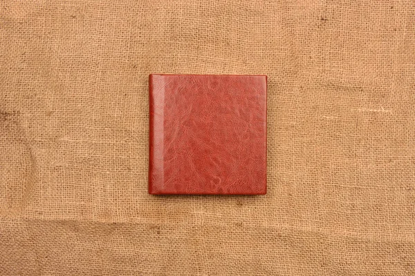 Изображение красновато-коричневой кожи обложки альбома на джуте backg — стоковое фото