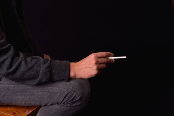 Feche a mão de um adolescente segurando um cigarro. Foto do estúdio. H — Fotografia de Stock