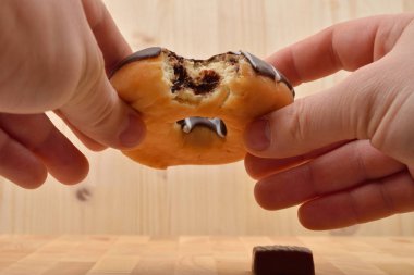 Bir ısırık halka choc ile onun elinde tutan bir adamın yakın çekim