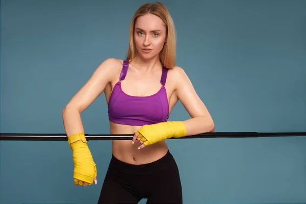 F Atleta de entrenamiento de boxeador femenino en vendajes de boxeo sobre un fondo azul —  Fotos de Stock