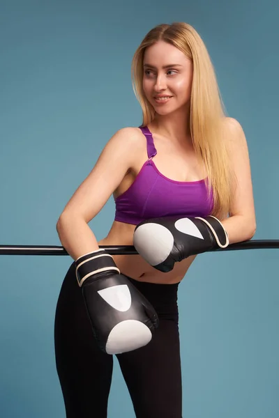 Mujer boxeadora con guantes de entrenamiento sobre fondo azul —  Fotos de Stock