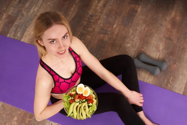 若い女性は健康的なランチを食べ、ヨガマットに座って — ストック写真