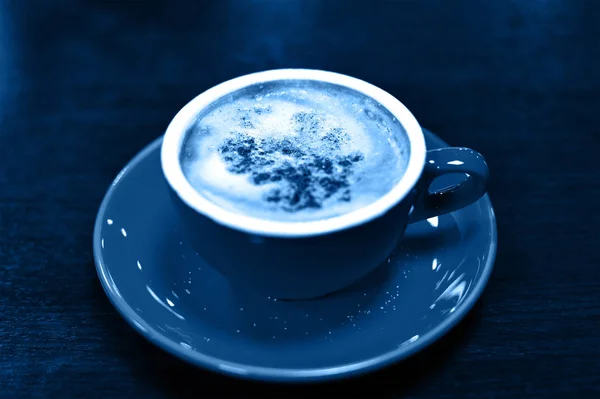 Colore dell'anno, 2020. Tazza di cappuccino o latte su fondo legno, tonica classica foto blu. tazza di caffè, vista dall'alto . — Foto Stock