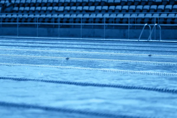经典的蓝色奥运游泳池，有竞赛车道。 2020年流行蓝色背景的色调. — 图库照片