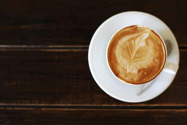 Filiżanka cappuccino lub latte na drewnianym tle. filiżanka kawy, widok z góry. — Zdjęcie stockowe