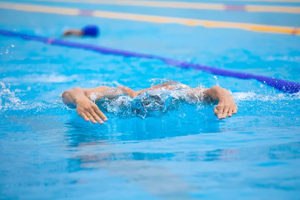 Atletisk man simmar i fjäril stil i poolen med klarblått vatten. — Stockfoto