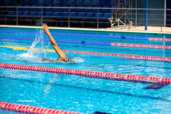 Atletisk man simmar framför krypa stil i poolen med klarblått vatten. — Stockfoto