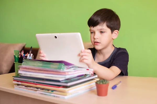 Chlapec používající tablet během domácí práce během karantény koronaviru. Koncept vzdáleného vzdělávání. — Stock fotografie