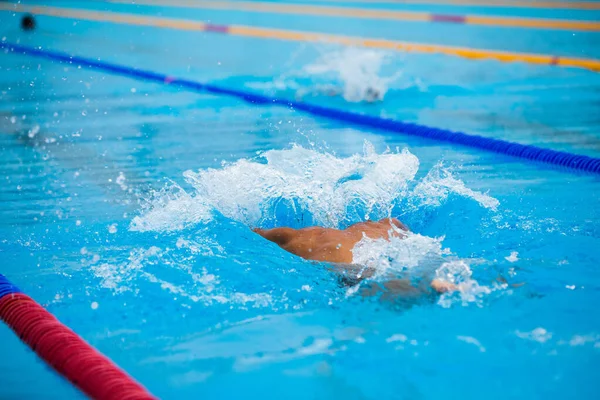 Atletisk man simmar i fjäril stil i poolen med klarblått vatten. — Stockfoto