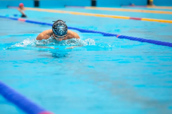 Sportovní muž plavání v prsa styl v bazénu. — Stock fotografie