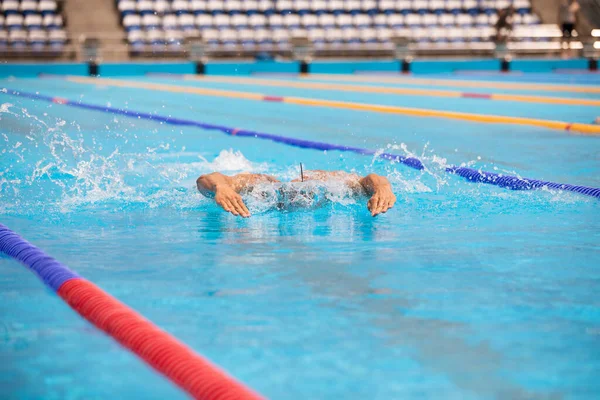 Atletisk man simmar i fjäril stil i poolen med klarblått vatten. — Stockfoto