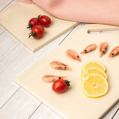 Yapay taştan yapılmış mutfak tahtasındaki domatesler ve kıvrımlar.