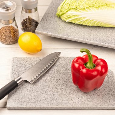 Kesici bir bıçakla suni taştan yapılmış bir kesme tahtasına biber parçası.