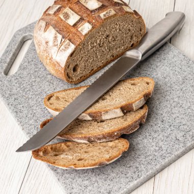 Yapay taştan yapılmış mutfak kesme tahtasında taze kokulu ekmek.