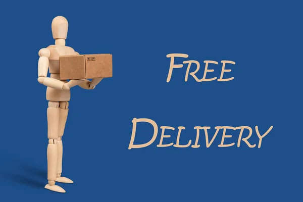 Toy man, delivery service worker with a cardboard box in his hands. Blue classic background. Delivery and Shipping Services Concept.