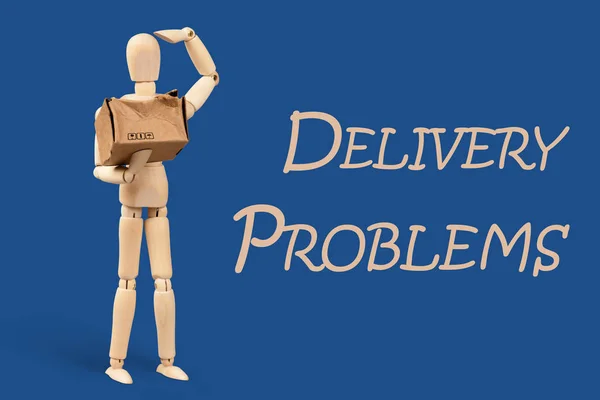 Toy man, delivery service worker with a cardboard box in his hands. The box is broken. Delivery service problem concept. Blue classic background
