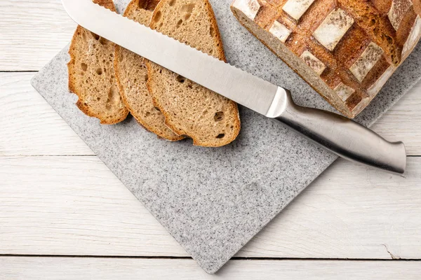 Pane fresco e profumato su un tagliere da cucina in pietra artificiale — Foto Stock