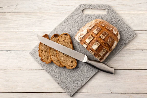 Pane fresco e profumato su un tagliere da cucina in pietra artificiale — Foto Stock