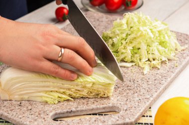 Şef yapay taşın üzerinde bir tabak lahana hazırlıyor..