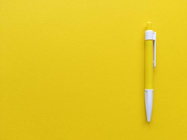Sarı arka planda sarı ve beyaz kalem. Kopyalama alanı olan minimalist düz bir yer. Stok fotoğrafı.