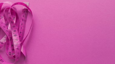 Pembe arka planda pembe santimetre. Pastel desenli düz bir yatak. Fitness konsepti. Stok fotoğrafçılığı.