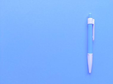 Arka planda mavi ve beyaz kalem var. Kopyalama alanı olan minimalist düz bir yer. Stok fotoğrafı.