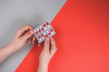 Kırmızı-gri arka planda manikürlü eller