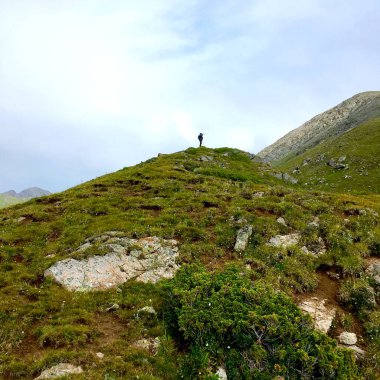 Dağ zirvesinde bir adamın silueti.