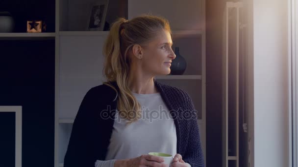 Žena při pohledu na její okna obývacího pokoje a fotoaparát 