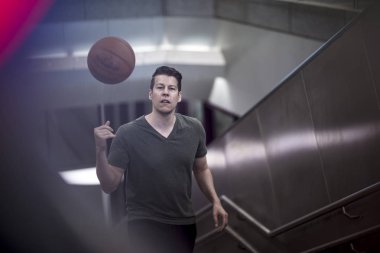 Merdivenlerden yukarı bir basketbol ile yürüyen adam