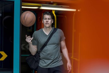 Sportif adam ile bir basketbol yürüyüş bir metro treninin dışında