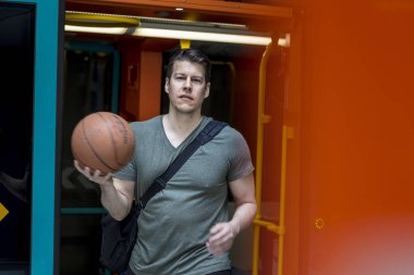 Sportif adam ile bir basketbol yürüyüş bir metro treninin dışında