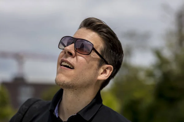 Headshot de l'homme avec des lunettes de soleil regardant le ciel — Photo