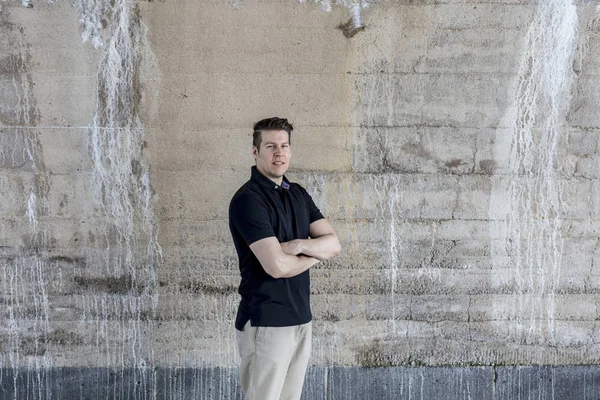 ベージュ色の壁の後ろに立っているカジュアルな服装の男 — ストック写真