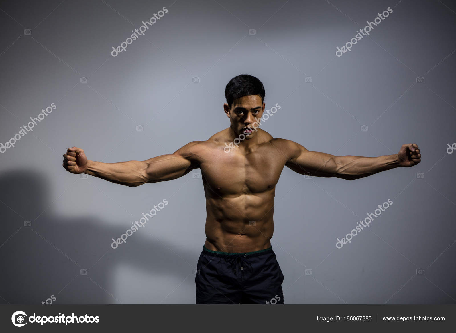 Fitness Model Displaying Biceps and Pectorals With Stretched Out
