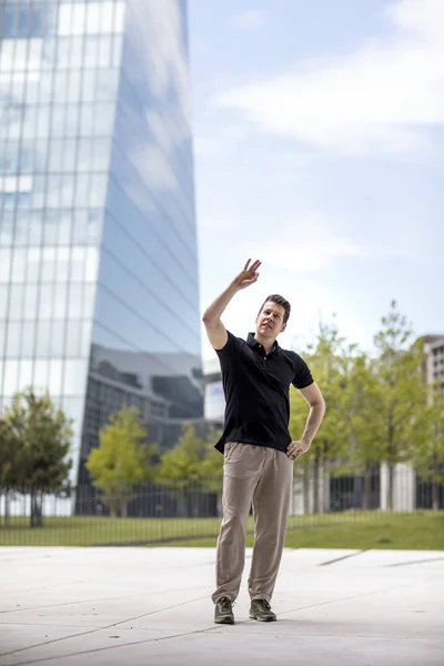 Hombre haciendo gestos de mano en frente del edificio de vidrio —  Fotos de Stock