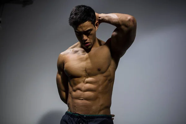 Asian Fitness Model Flexes Muscular Abdomen