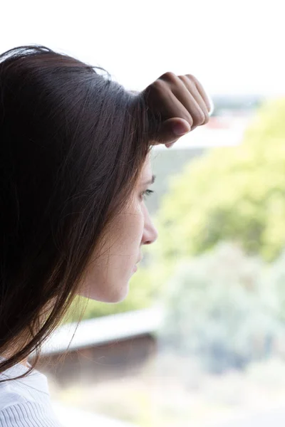 Rostro de mujer joven inclinada cabeza en la ventana — Foto de Stock