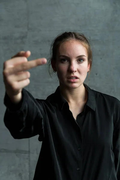 Retrato de mujer joven dando el dedo medio — Foto de Stock