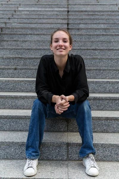 Fiatal nő ül a szabadban Lépcső vigyorog a kamera — Stock Fotó