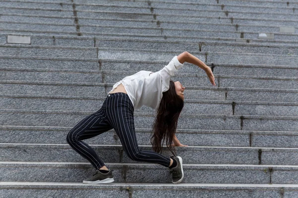 Молодая женщина делает спину стоять на мраморных ступенях — стоковое фото