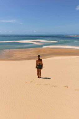 woman with green bikini overlooking sand banks and turquoise water