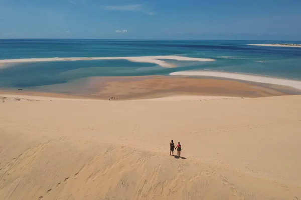 Casal de mãos dadas na praia com água azul-turquesa — Fotografia de Stock