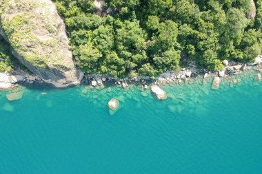 Yeşil kayalık orman ve mavi su insansız hava aracı ile üst görüntü görüntüsü