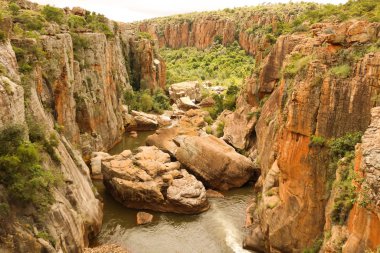 Nehir ve yeşil flora ile Kanyon Kayalıkları
