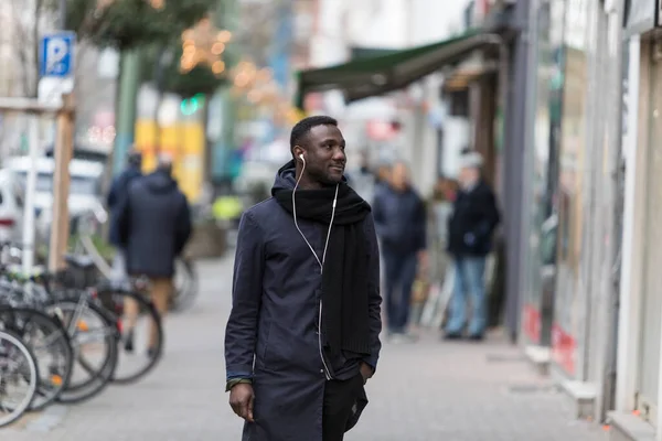 Joven Hombre Negro Escuchando Auriculares Acera Ciudad Con Cabeza Vuelta —  Fotos de Stock